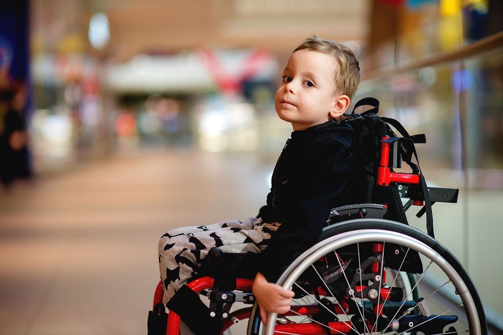 Boy with neuromuscular condition, seated in wheelchair — Invitae genetic testing blog