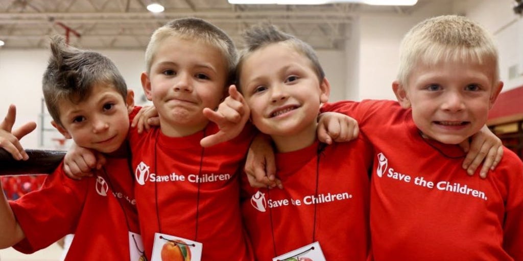 four children with their arms across each other’s shoulders