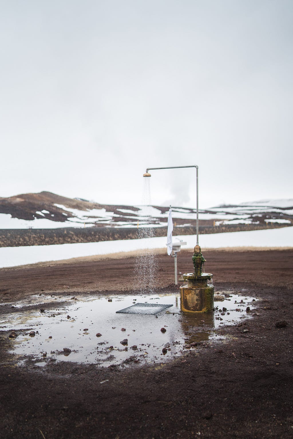 Outdoor shower with backdrop of snowy mountains