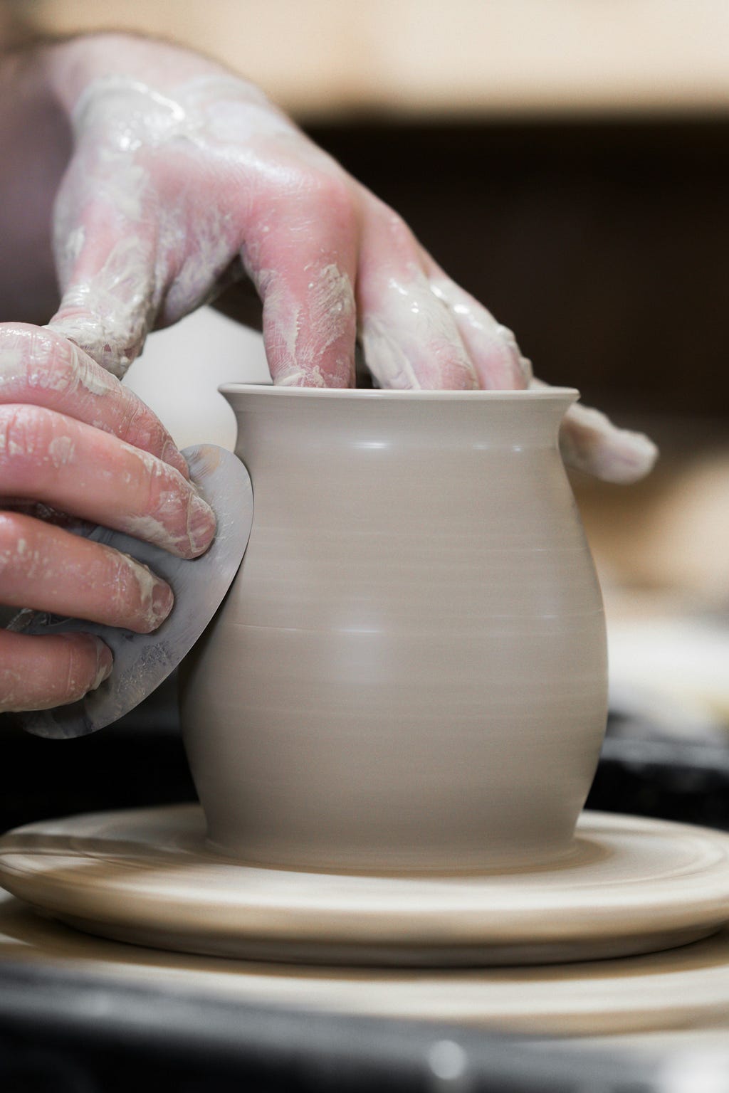 a potter makes a clay pot on a pottery wheel