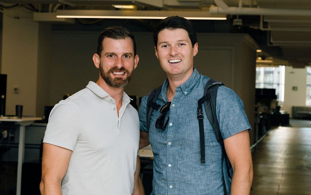 Tim stands side by side with Justin, our Chief Product Officer, both smiling at a company event.