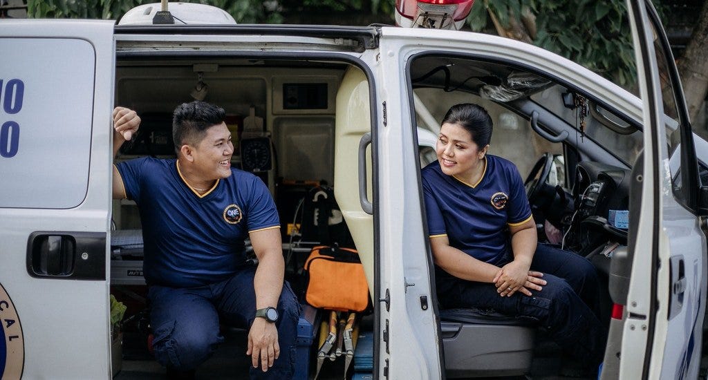 A man and woman sitting in a medical van