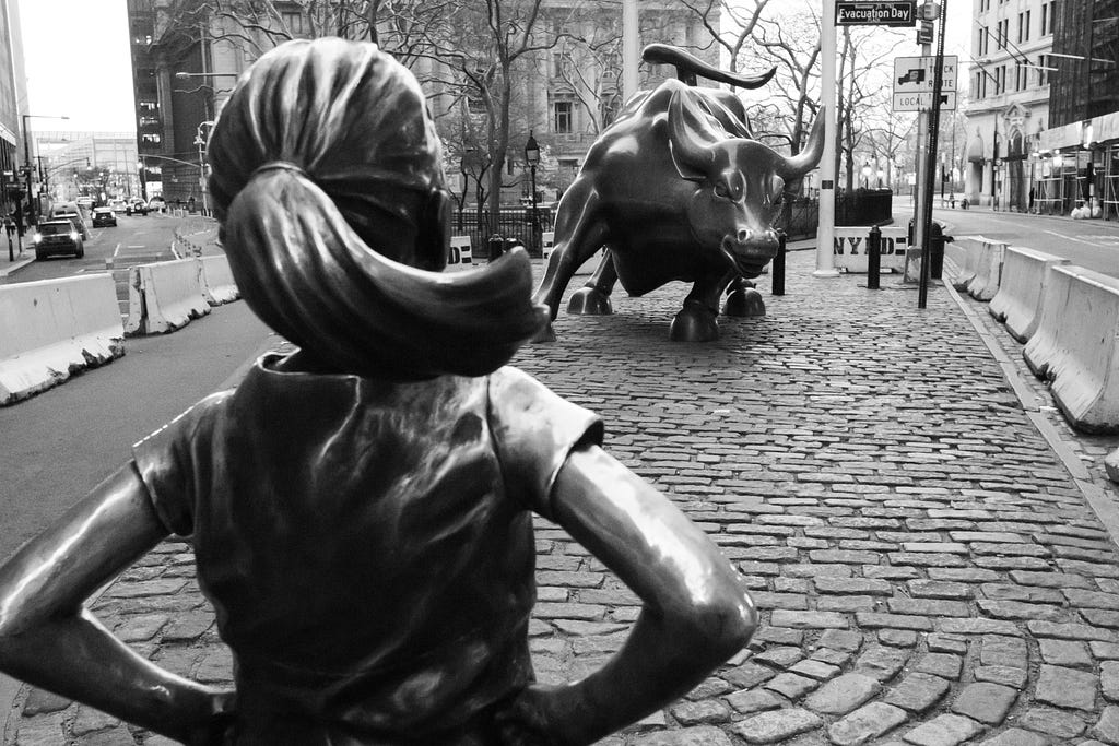 The fearless girl in front of the wall street charging bull