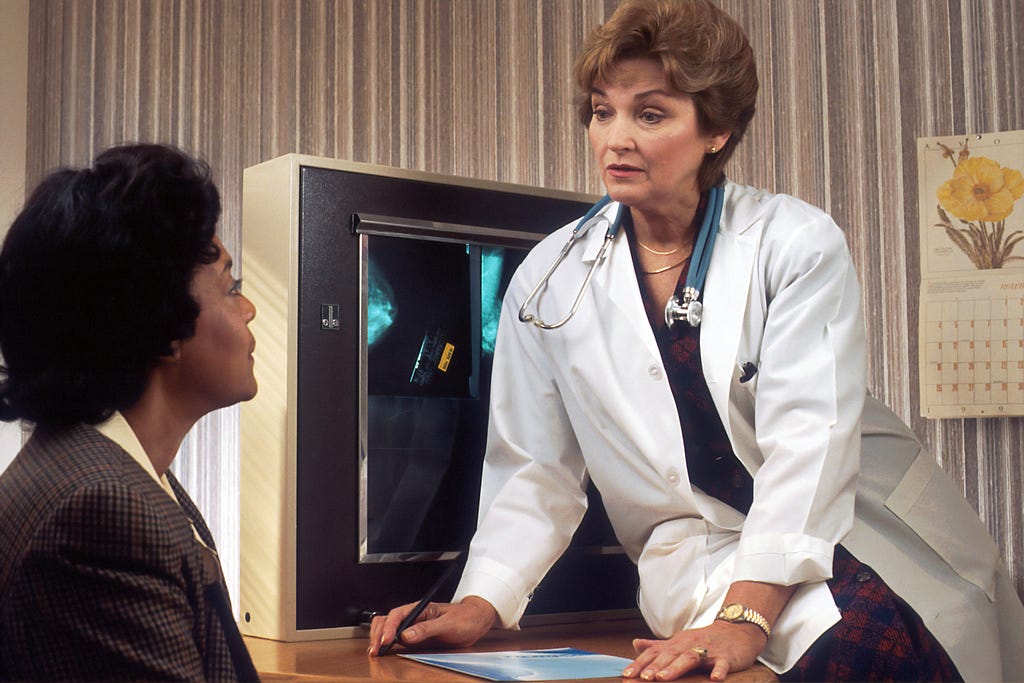 A black, female patient having an appointment with a white doctor.