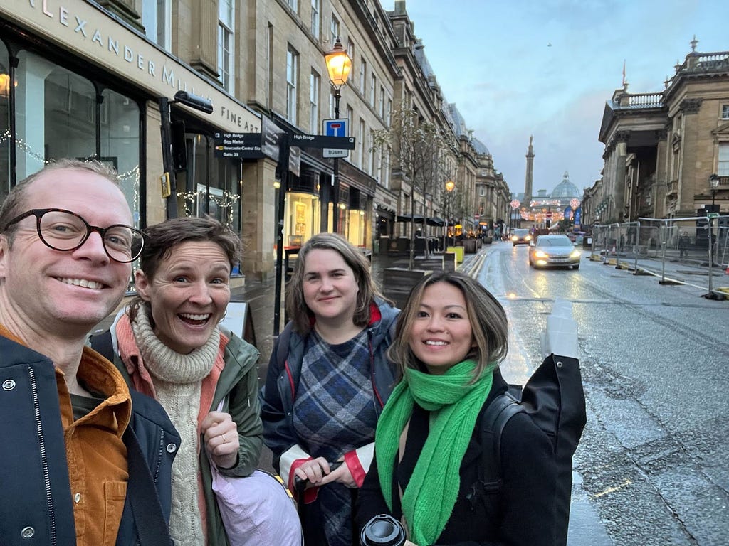Chris, Jess, Audrée, and Saw pictured on Grey Street in Newcastle with Grey’s monument in the background.