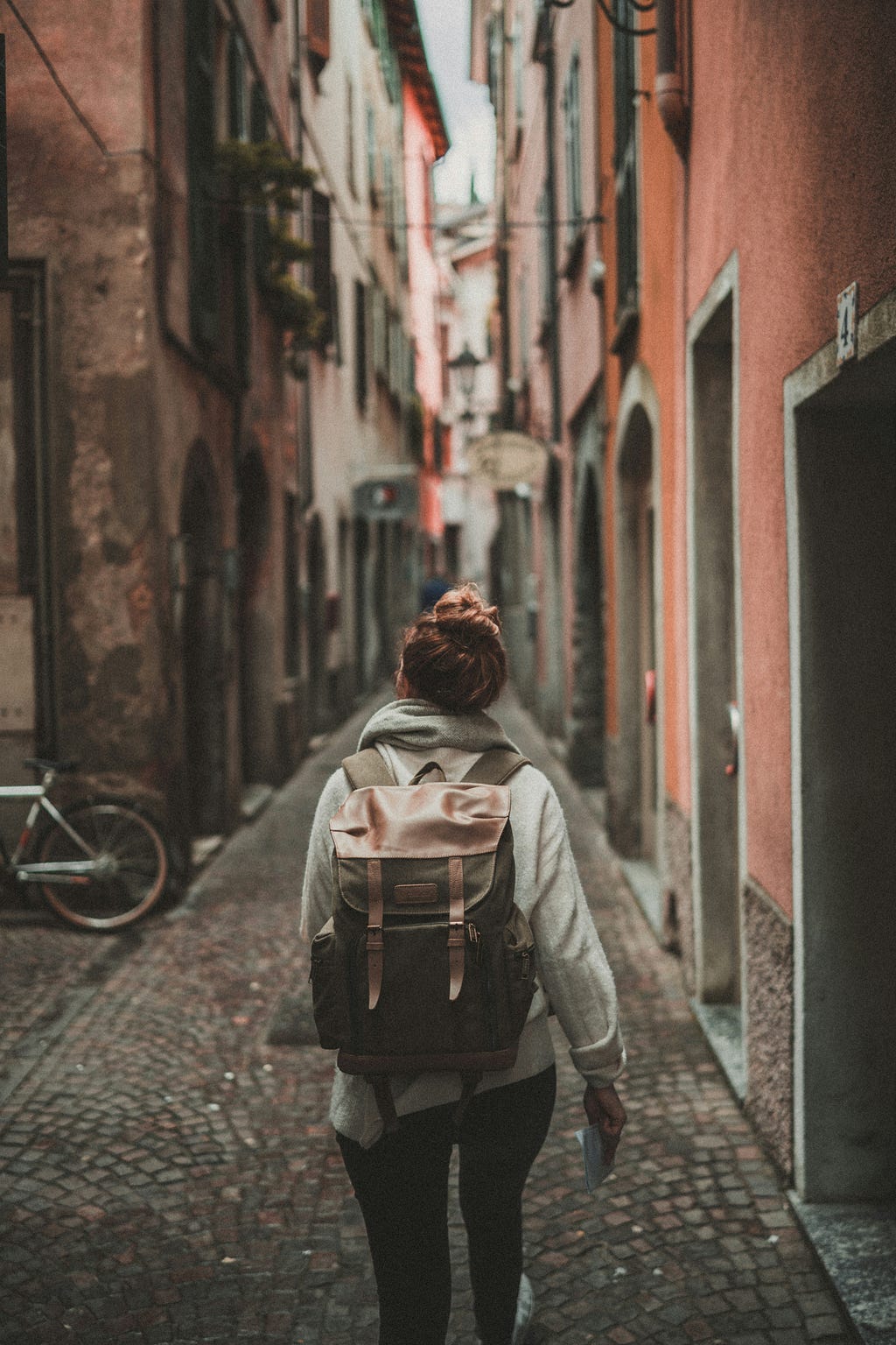 Backpacker walking old rustic alley way in a European city.