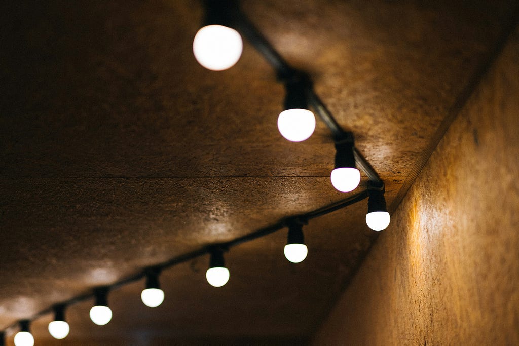 Images of LED bulbs hanging on a wall, emitting bright white light.