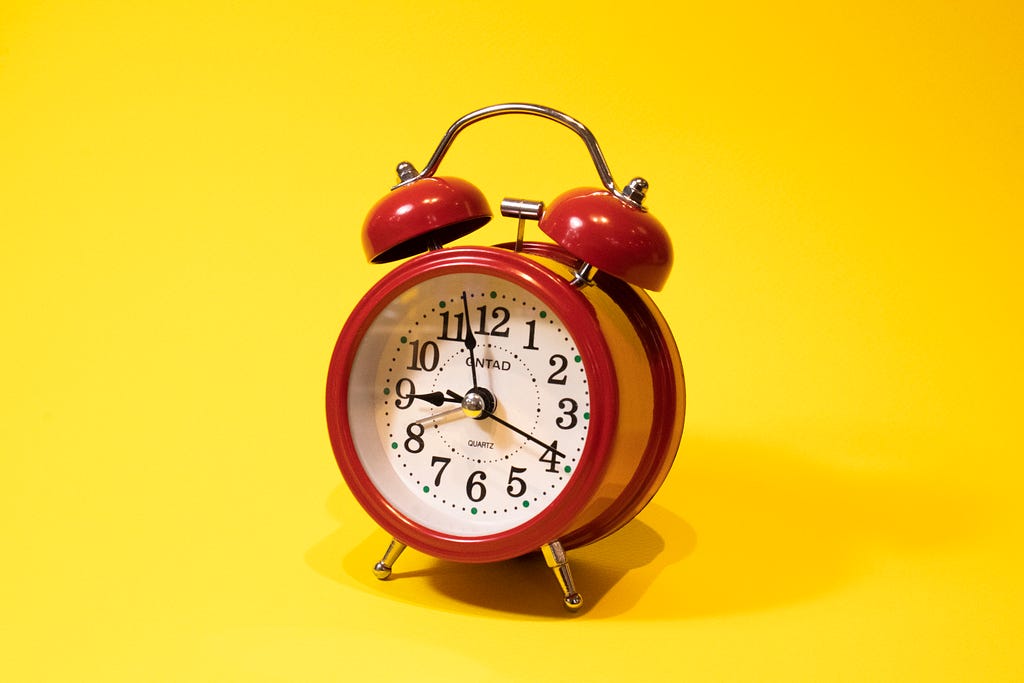 Yellow background with red alarm clock