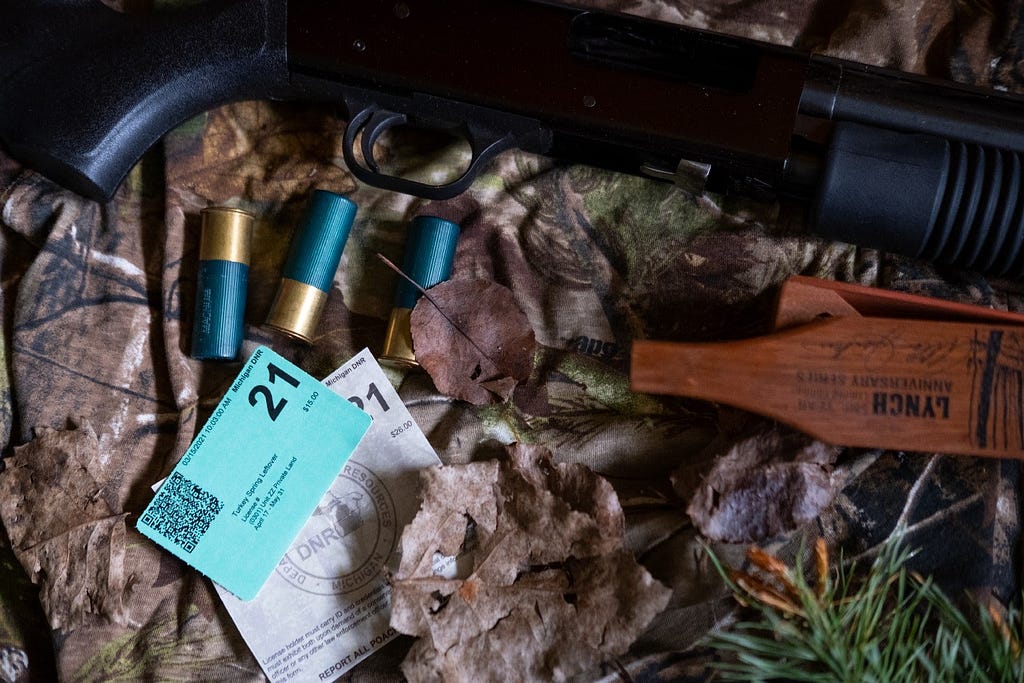 Hunting shotgun with turkey call and hunting license