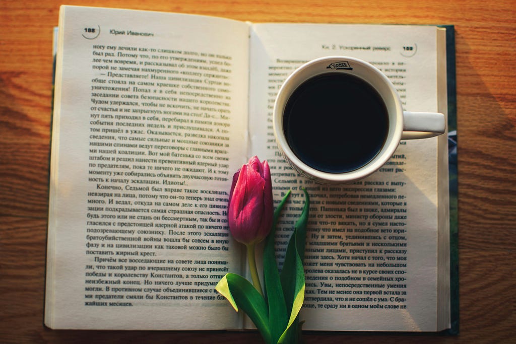 a picture of a paper book with a tulip and a cup of coffee