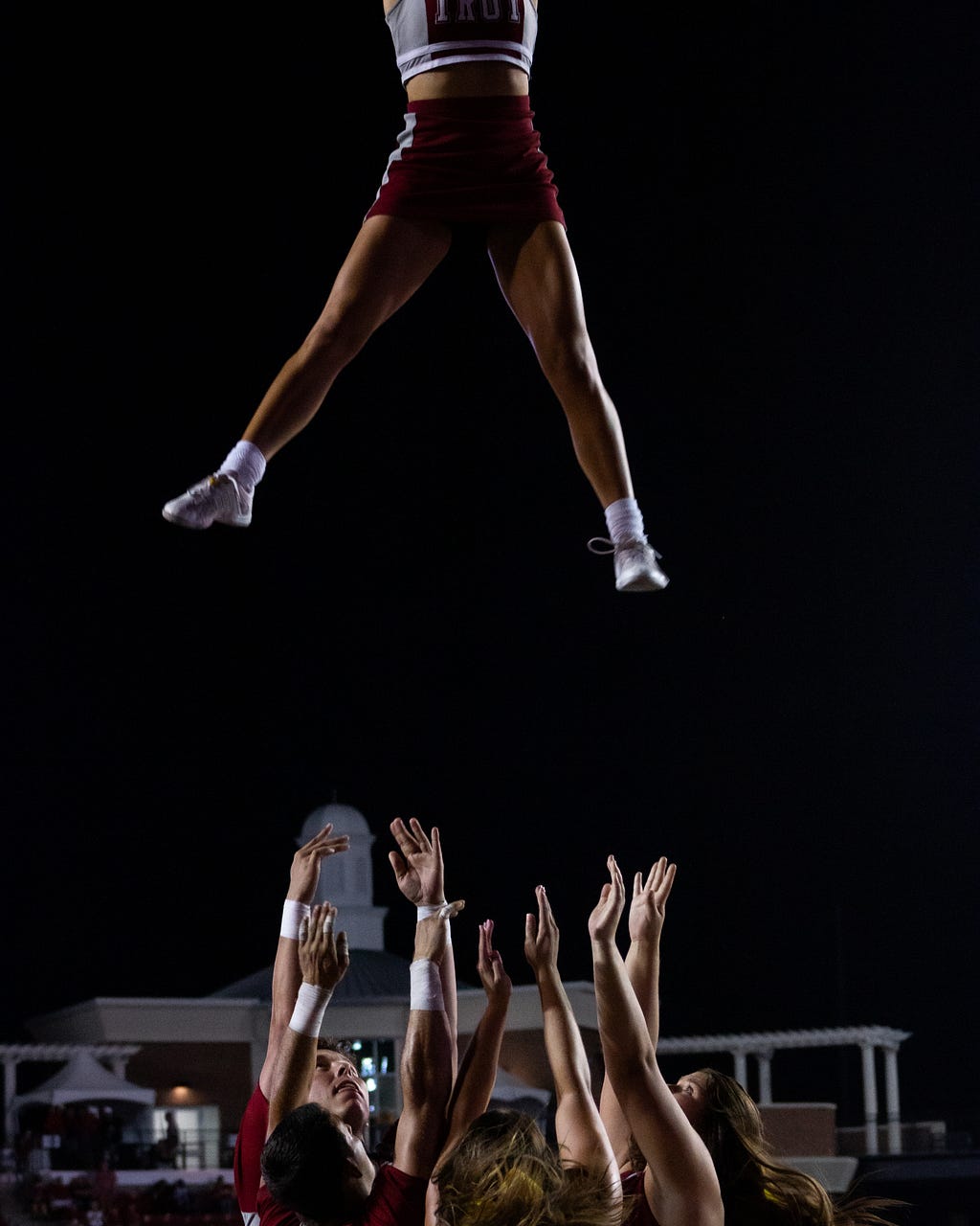 Cheerleading team tossing a member in the air