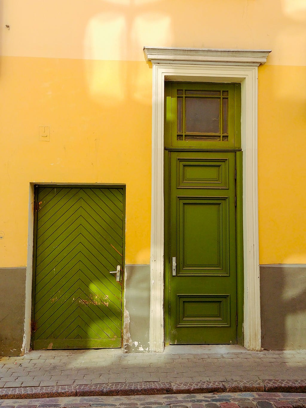 Colorful comparison of two green doors — similar in color but different in height, texture, and style.