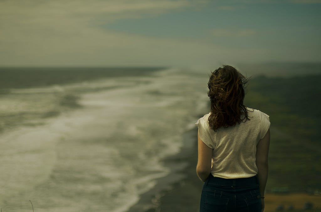 A woman standing by the sea shore