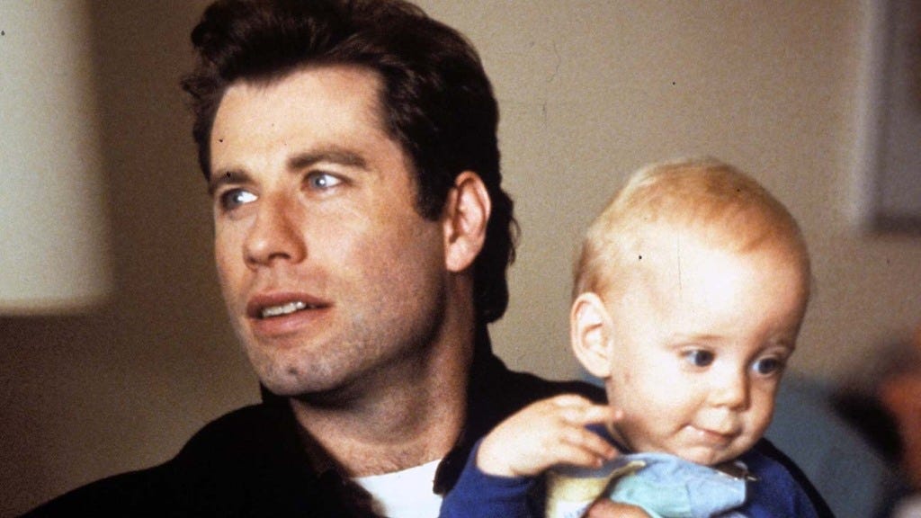 A scene of the movie Look Who Is Talking showing John Travolta holding a baby.