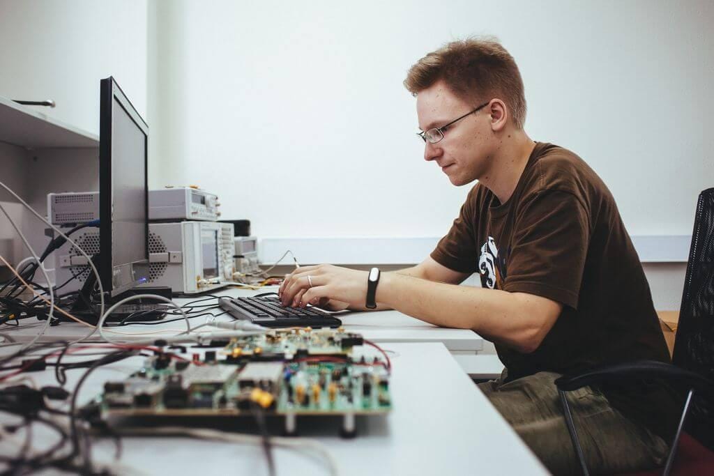 Promwad engineer testing software on a dev board.