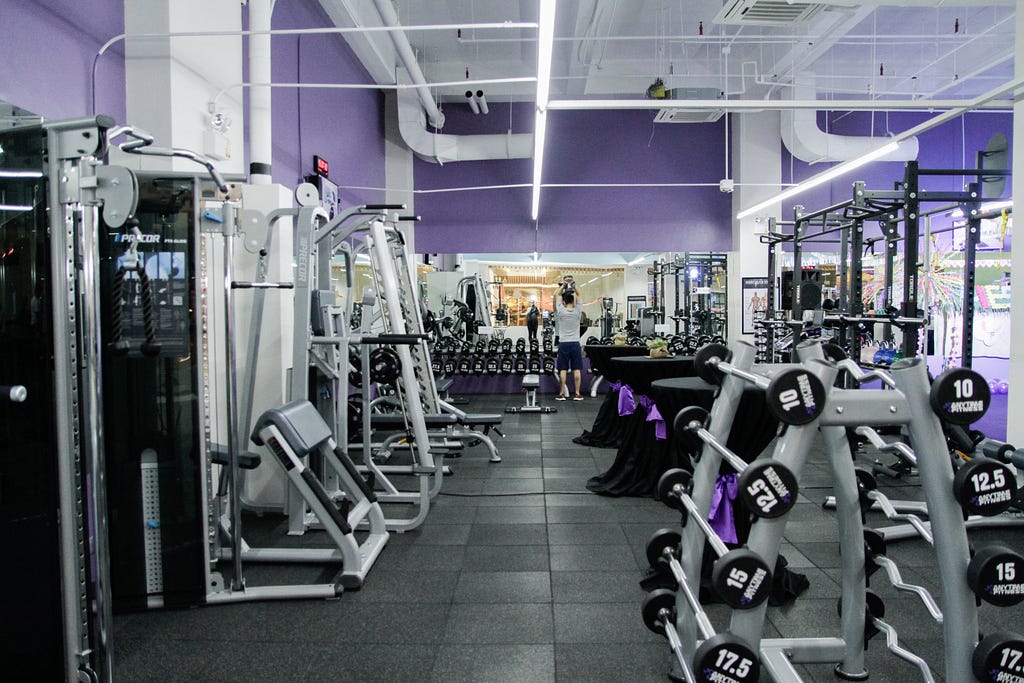 Gym equipment in a largely empty gym