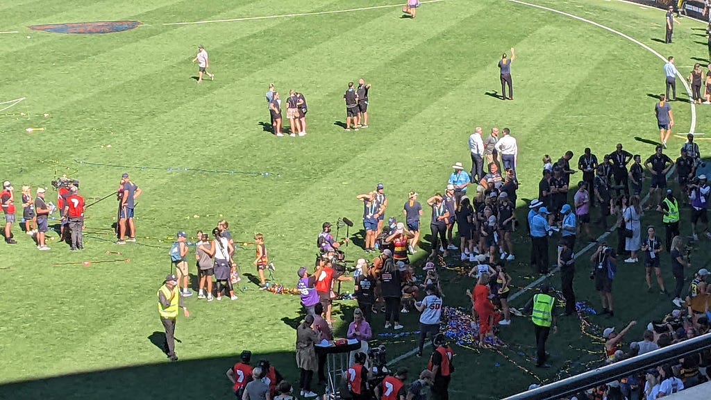 Players, staff and families celebrate the Adelaide AFLW premiership on the ground