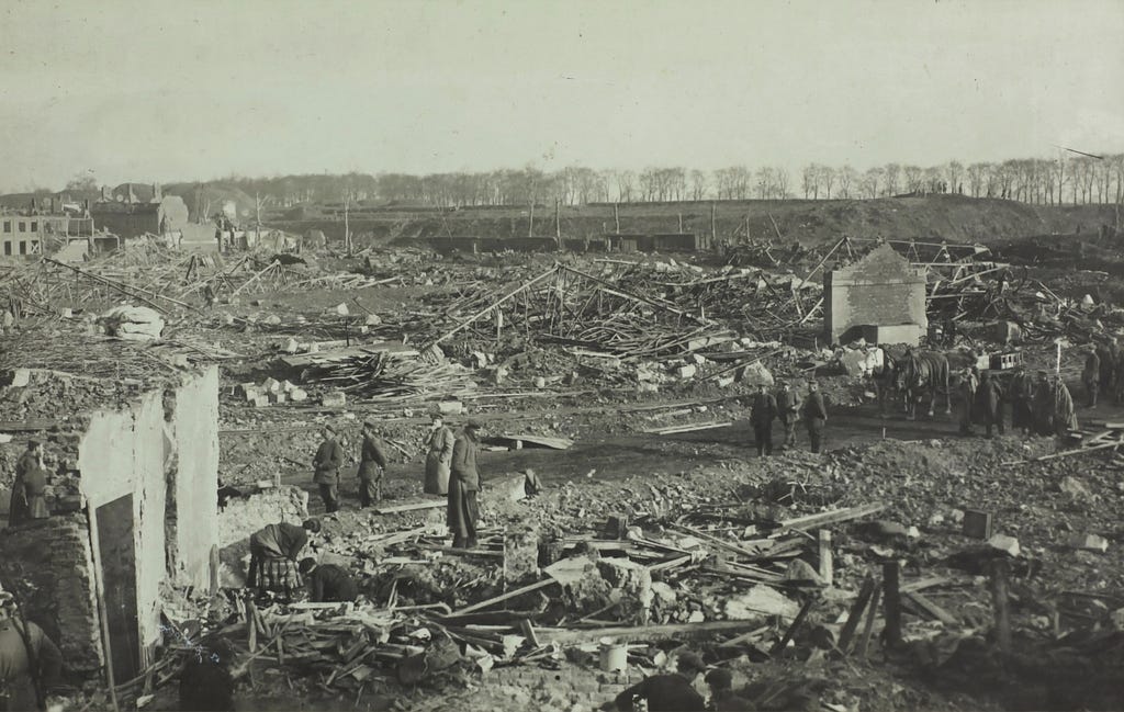 Soldiers survey and move through destroyed buildings