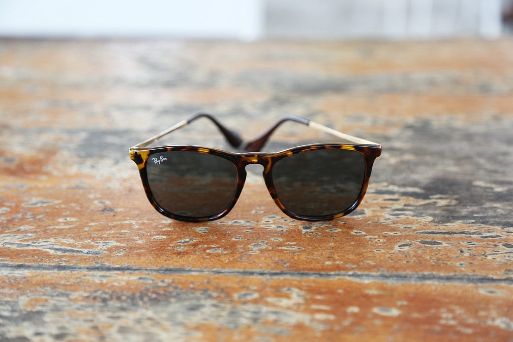 Tortoise-shell RayBan Wayfarer sunglasses, circa 1992, on a picnic table