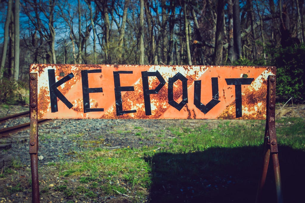 A rusty, handwritten “keep out” sign.