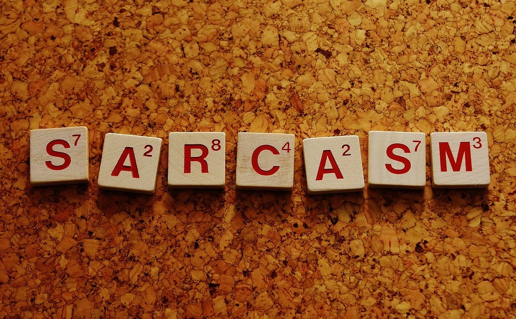 The word ‘sarcasm’ written on indivudual wodden blocks.