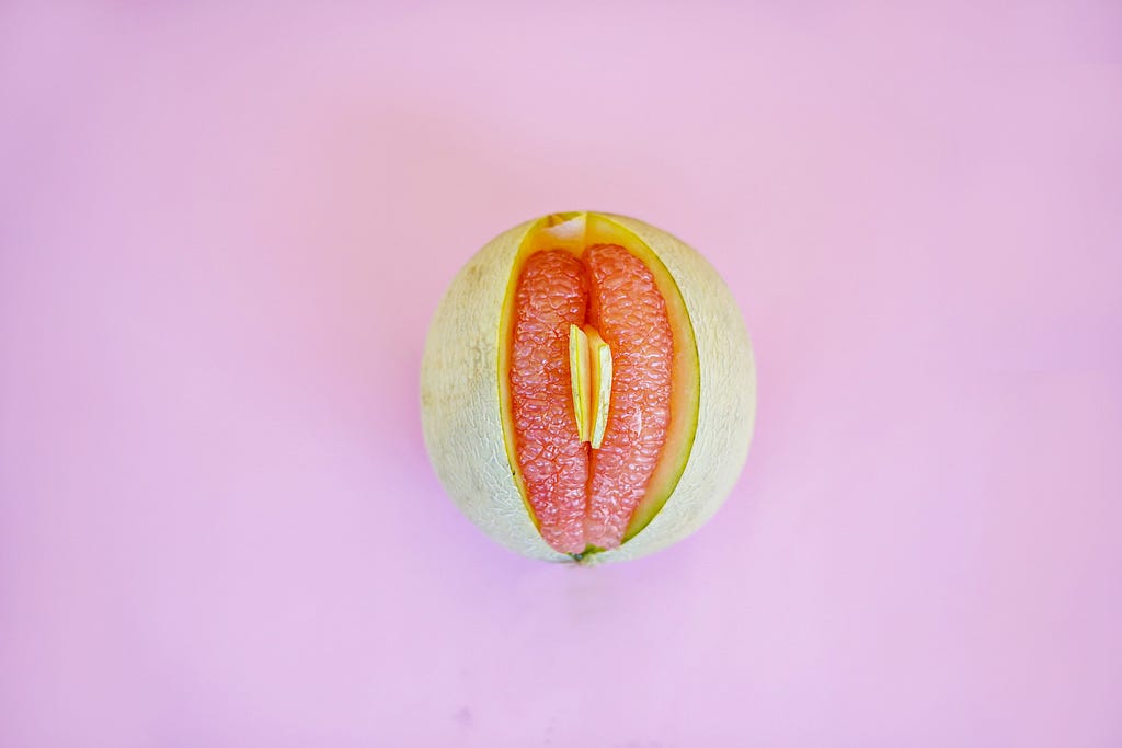 Photo of a honeymelon with grapefruit slices inside it to depict a vulva