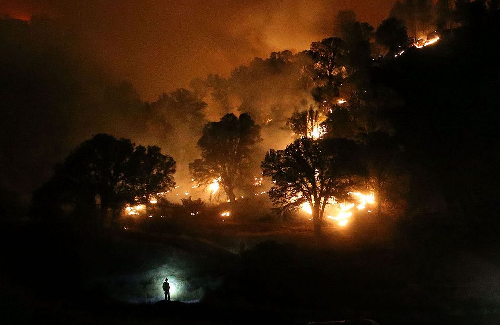 CLEARLAKE, CA - AUGUST 03: A Cal Fire firefighter is silhouetted by his headlamp as he monitors a backfire while battling the Rocky Fire on August 3, 2015 near Clearlake, California. Nearly 3,000 firefighters are battling the Rocky Fire that has burned over 60,000 acres has forced the evacuation of 12,000 residents in Lake County. The fire is currently 12 percent contained and has destroyed at least 14 homes. 6,300 homes are threatened by the fast moving blaze. (Photo by Justin Sullivan/Getty Images)