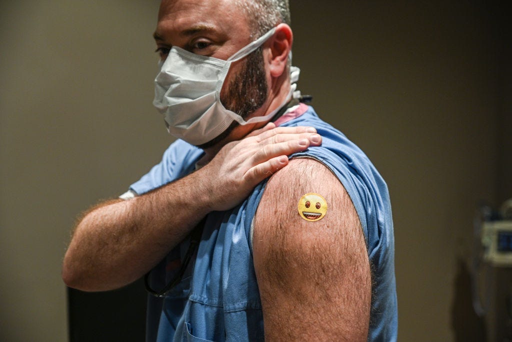 Dr. Jason Smith shows off his bandage after getting vaccinated at the University of Louisville Hospital in Kentucky.