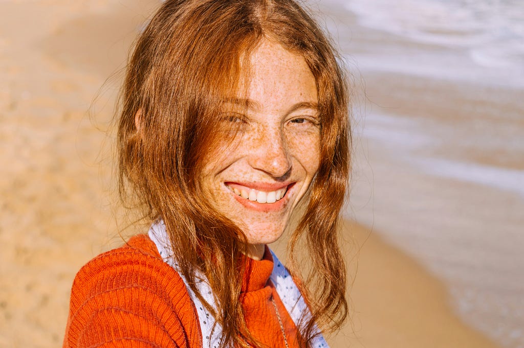 A woman who is smiling at the beach.