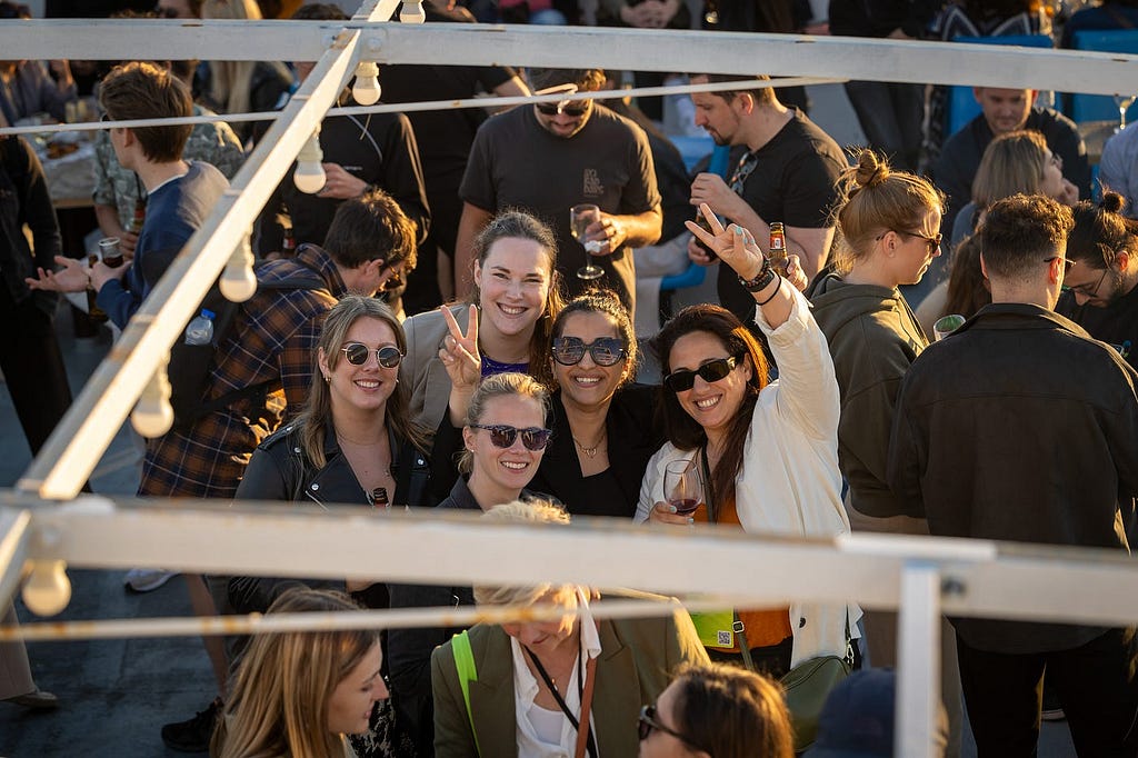 Group of attendees smiling and gesturing for the photo on the boat deck.