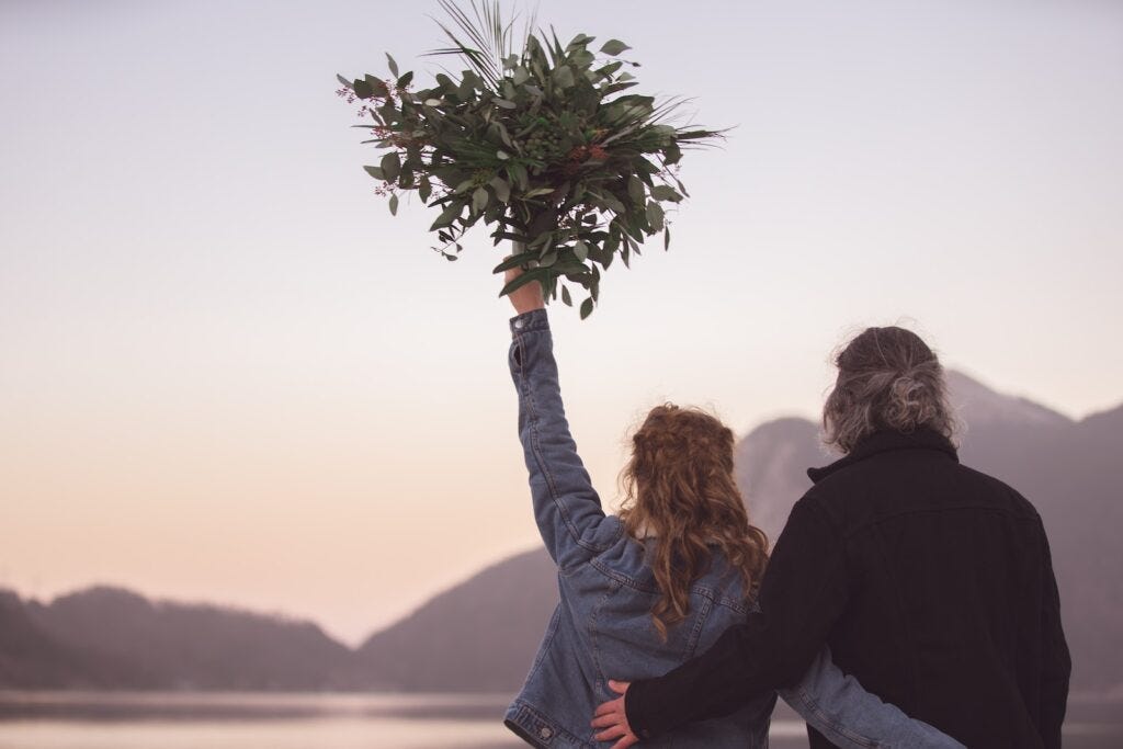 woman in black jacket holding green plant