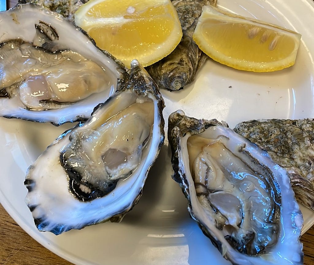 A photo of an oyster dish with lemon as garnish.