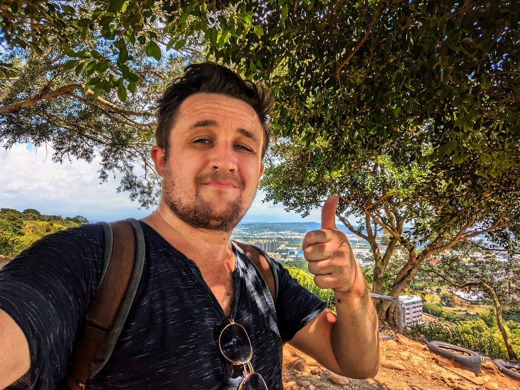 I am giving a thumbs up at the top of teh mountain.