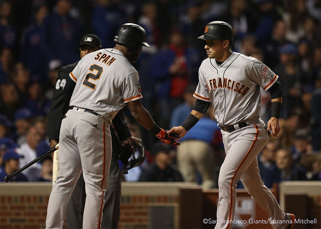 Joe Panik high fives Denard Span after scoring on a double hit by Gregor Blanco in the third inning.