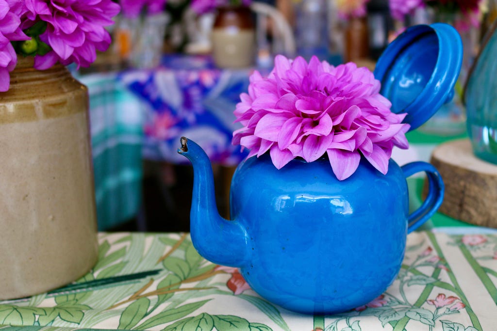 A blue teapot on a table.It reminds of simple joys in life.