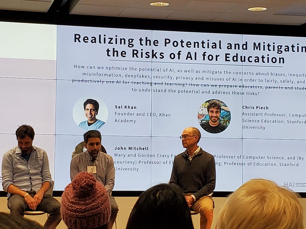 Sal Khan, Chris Piech, and John Mitchell sitting on stage in front of a slide projected on the wall titled “Realizing the Potential and Mitigating the Risks of AI for Education”