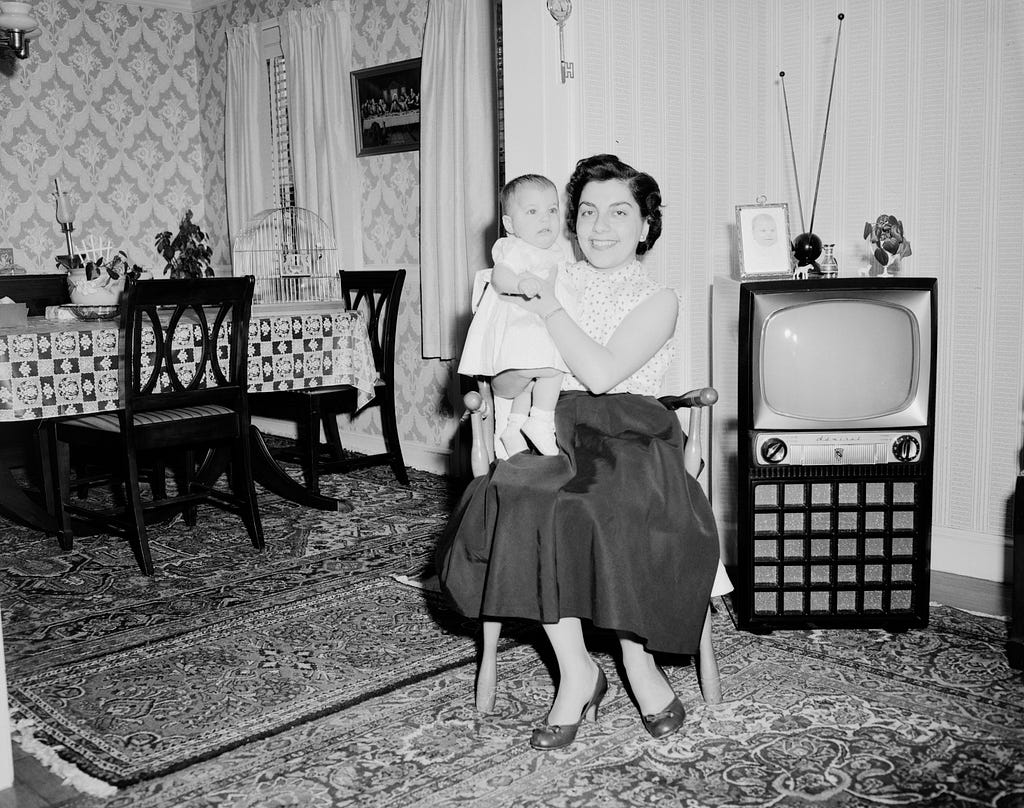Old picture of a living room, old television, lady and baby