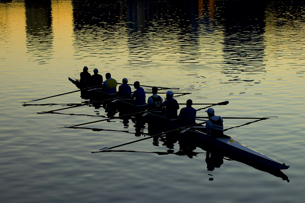 A group of people rowing together in a canoe.