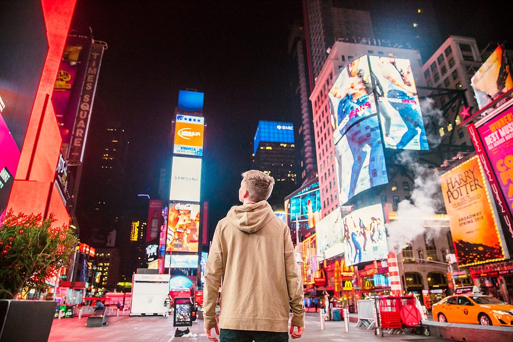 A man looking at Times Square’s digital screens and billboards