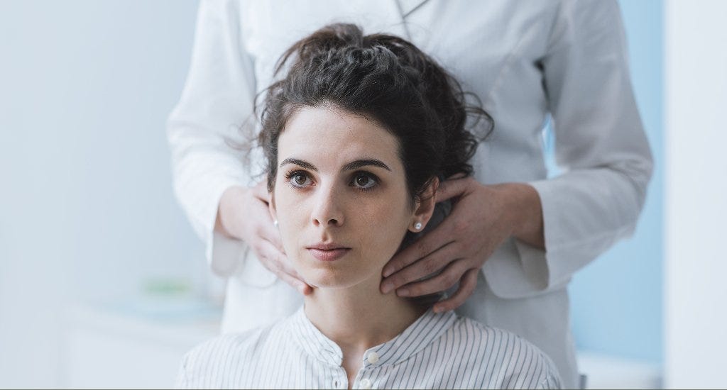A woman having her lymph nodes checked by a doctor