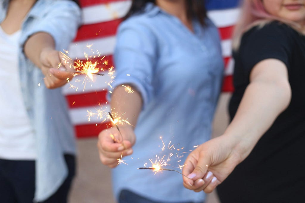 group of women friends holding sparklers in their hands