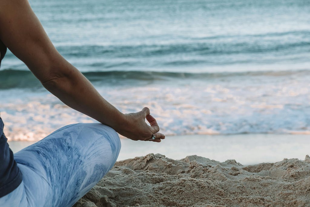 A girl practices mindfulness alone at the edge of the beach