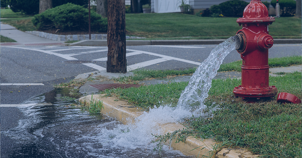 Picture showing water pouring from a broken water hydrant.