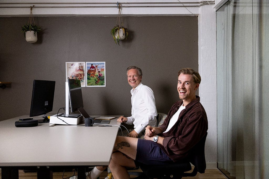 Tav Klitgaard and Lasse Finderup sit at an office desk