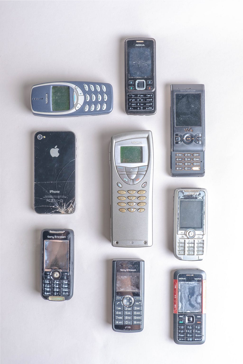 Old cellular phones from Nokia, Apple, and Sony Ericsson. Outdated or nostalgic?
