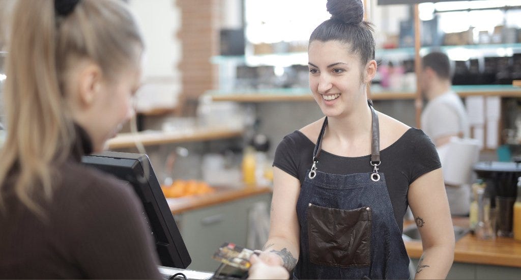 Cashier smiling while helping customer