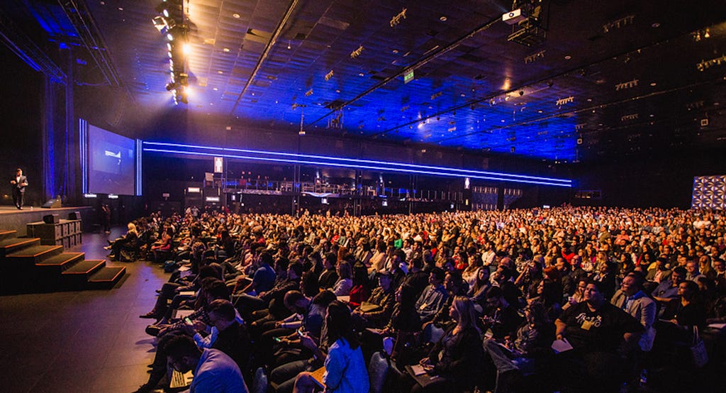 A large audience looking towards an small stage