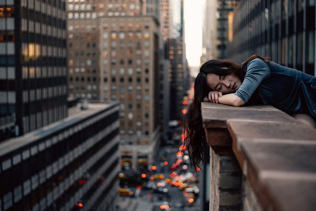 Woman leaning on the brick railing of her balcony