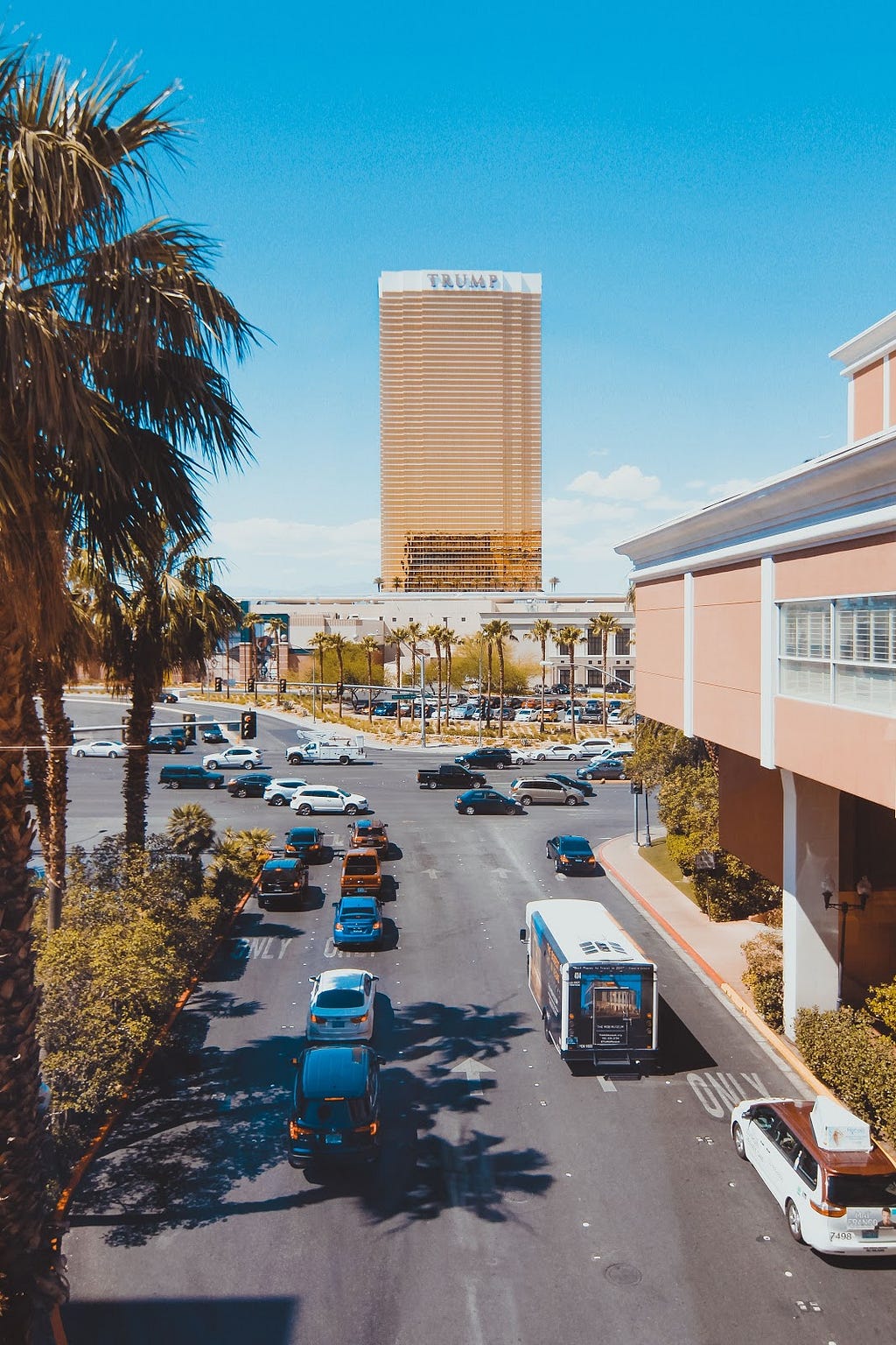 The Trump Hotel in Las Vegas and cars on the street in front of it.