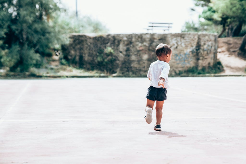 2 or 3 year old child running away from the photographer, probably to be playful but it conveys me wanting to run away from the Internet as well